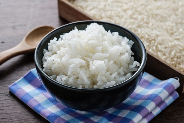 a black bowl of rice on a table.
