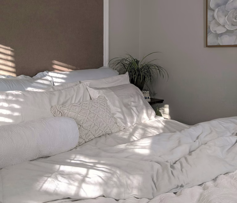 Calm bedroom with white bedding in soft morning light